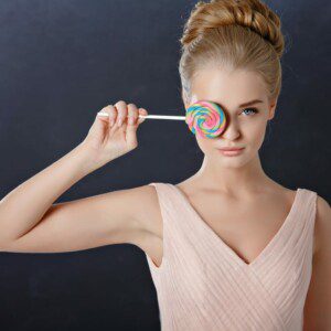 fashion model holding a lollipop over her right eye to represent image optimization