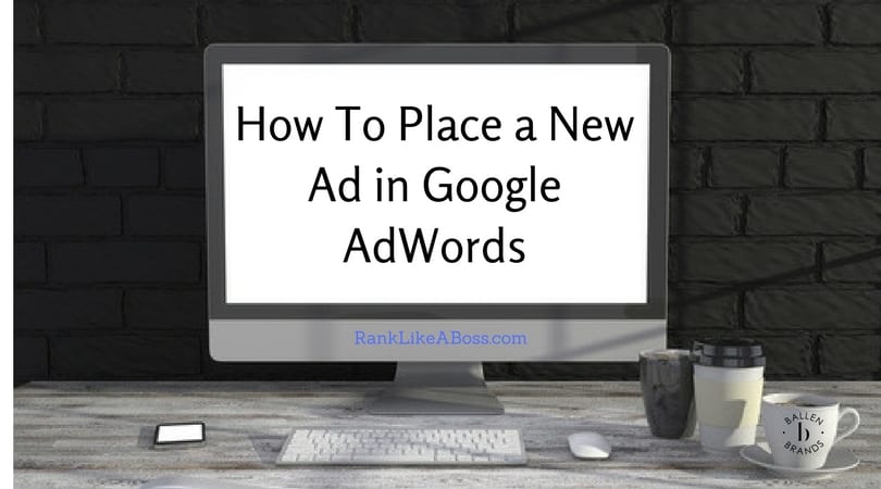 Large computer is on a desk, wall behind it is dark. On the desk is a coffee mug, water glass, iphone. Computer reads "how to place a new ad in google adwords"