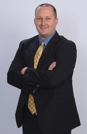 Reed Wilson Virginia Real Estate Agemt os stamdomg om a suit and yellow tie smilinmg