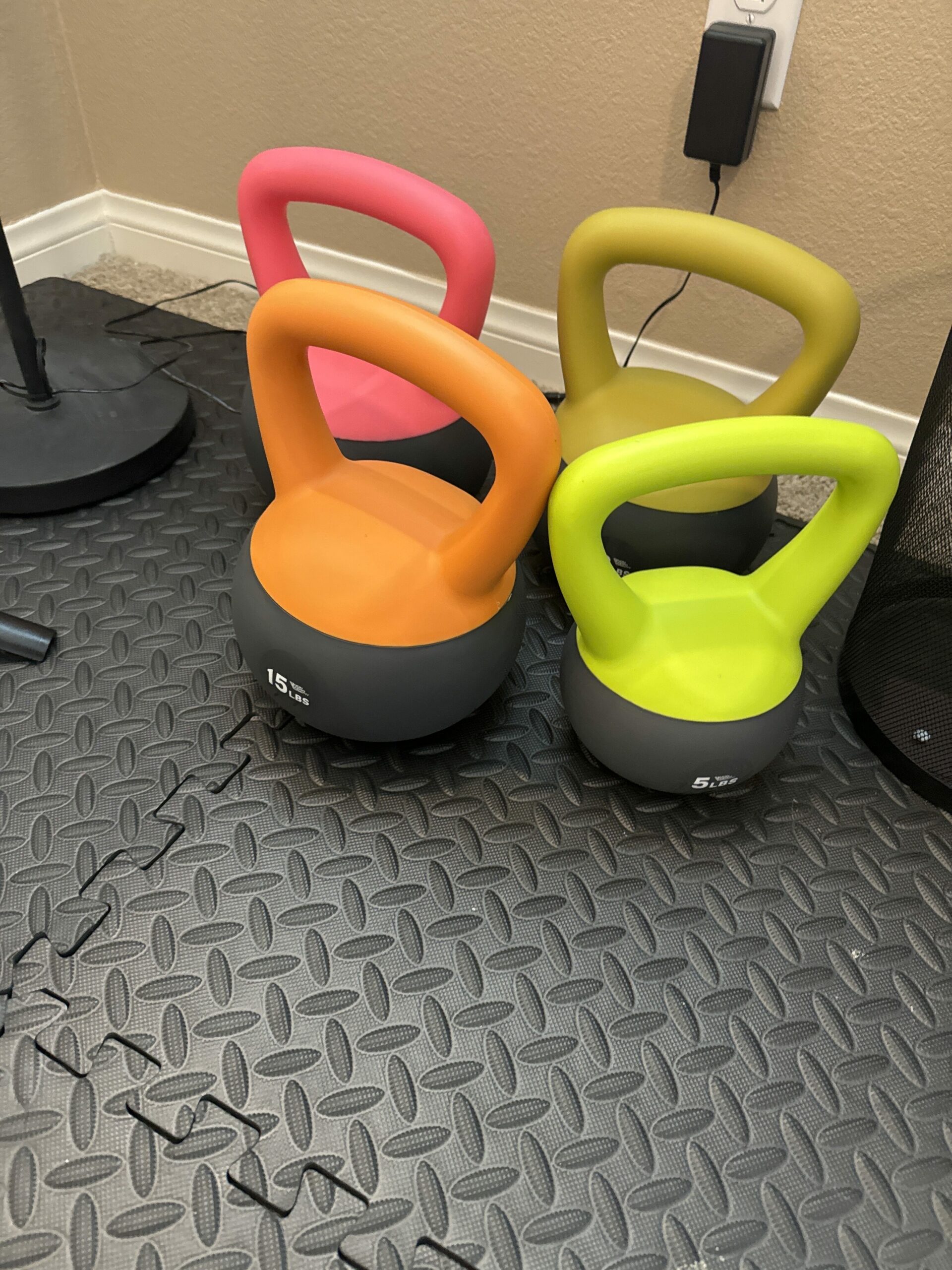 This image showcases a set of colorful kettlebells (15 lbs and 5 lbs), ideal for strength training exercises. These kettlebells are a great addition to the home gym for a variety of workouts targeting different muscle groups.
