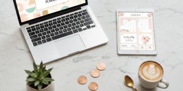 Laptop and tablet showing digital product designs on a marble desk — digital product ideas guide