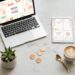 Laptop and tablet showing digital product designs on a marble desk — digital product ideas guide